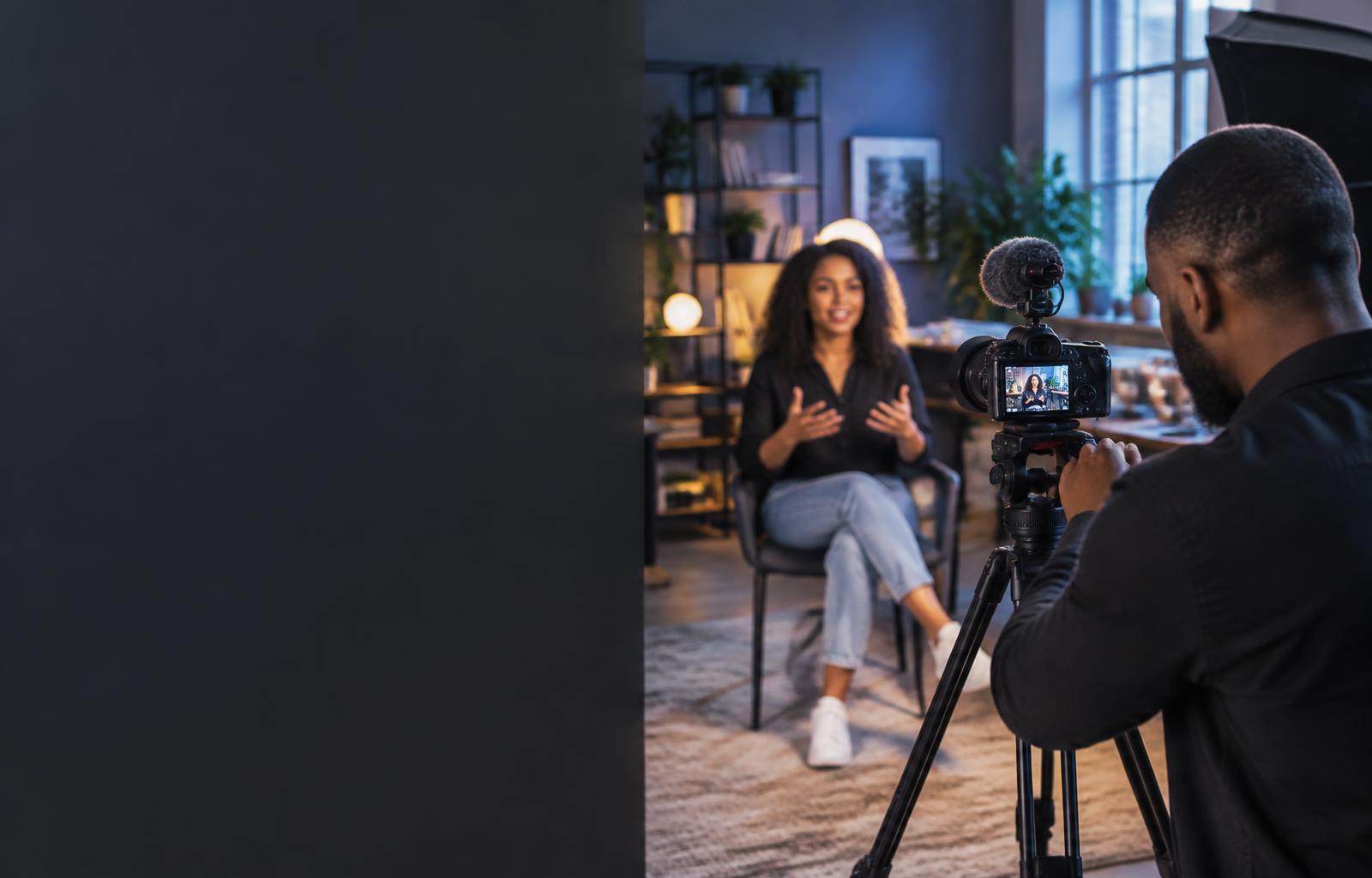 Illustrative content-production scene with a videographer recording a business owner